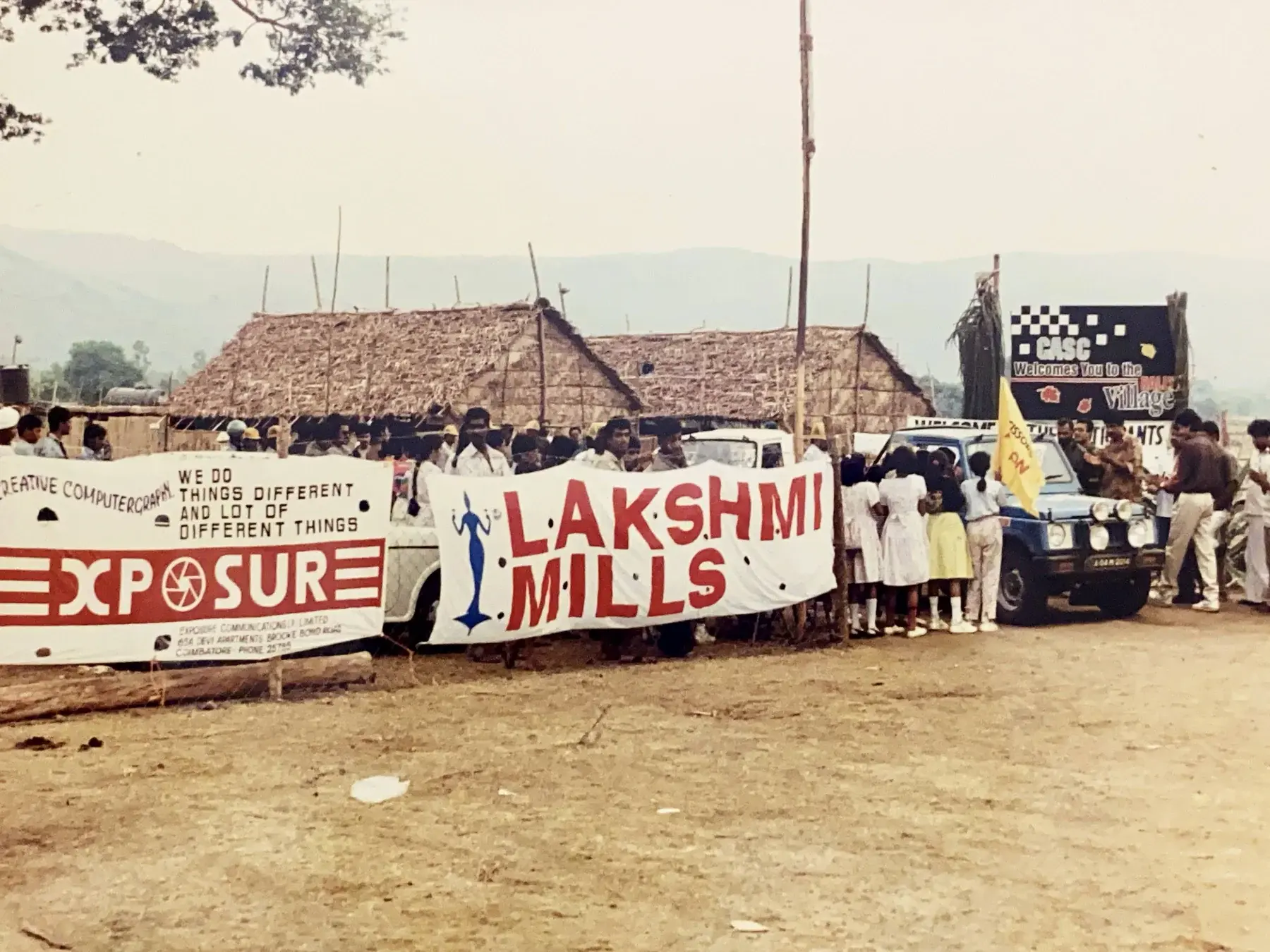 Exposure and Lakshmi Mills banners at a sponsored rally event