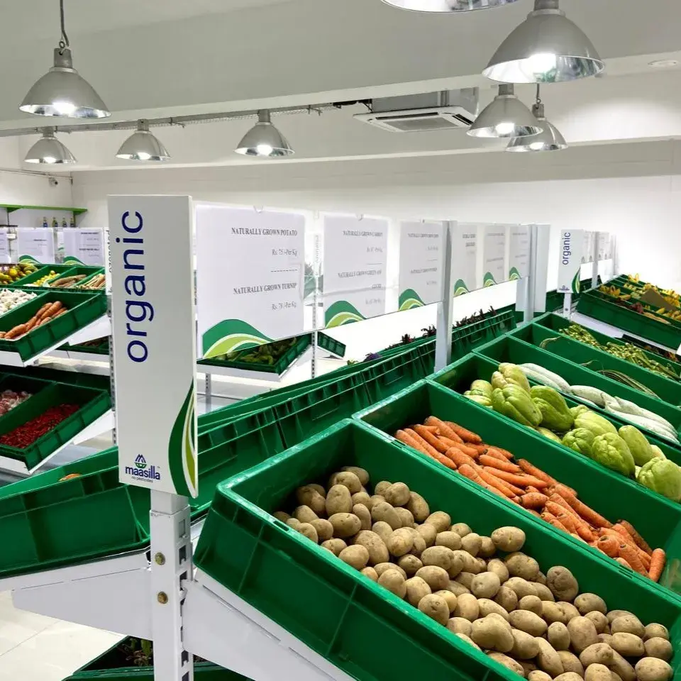 Maasilla store interior - Organic category wayfinder totem in brand blue with shelf price inserts