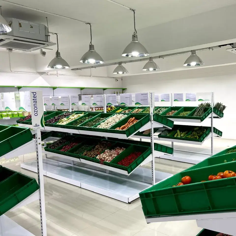Maasilla store interior with Ozonated category wayfinder totems and branded green produce crates