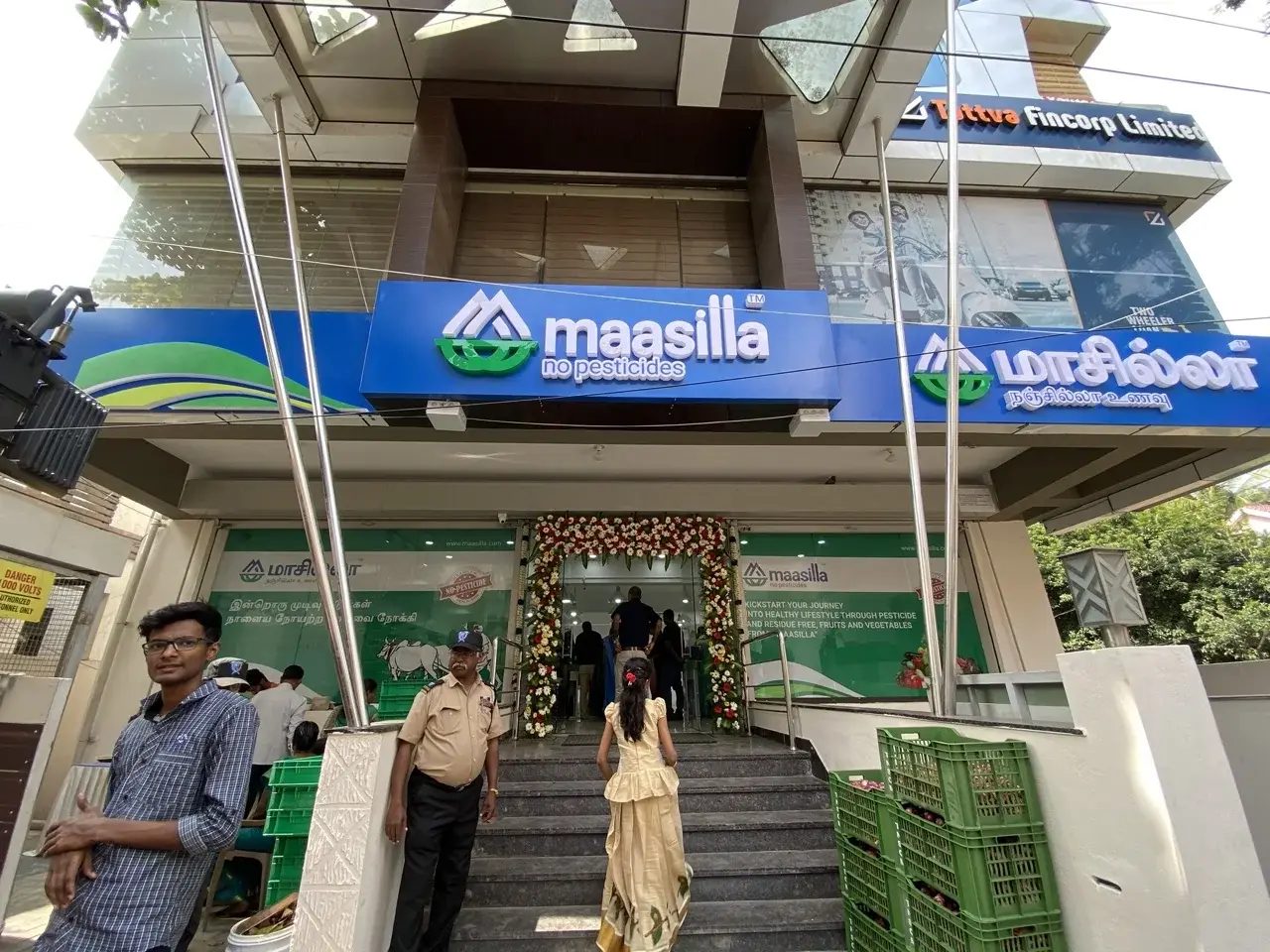 Maasilla storefront on launch day at RS Puram, Coimbatore - bilingual signage with flower garlands across the entrance.