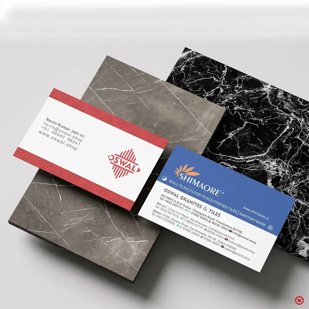 Oswal Granites & Tiles - new brand business card alongside old Shimaore card, displayed on granite tile samples